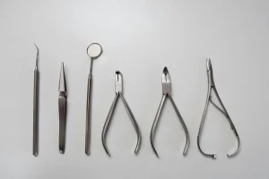 ustensiles et outils chirurgicaux posés sur un fond gris
